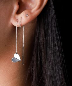 Mulher usando brinco de prata tipo coração