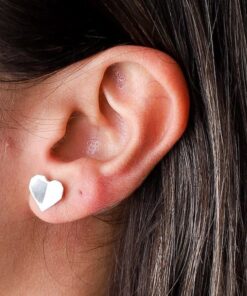 Mulher usando brinco de prata tipo coração