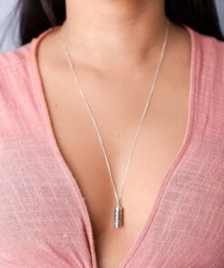 Modelo feminina de camisa rosa usando um colar Garrafinha Mosaico