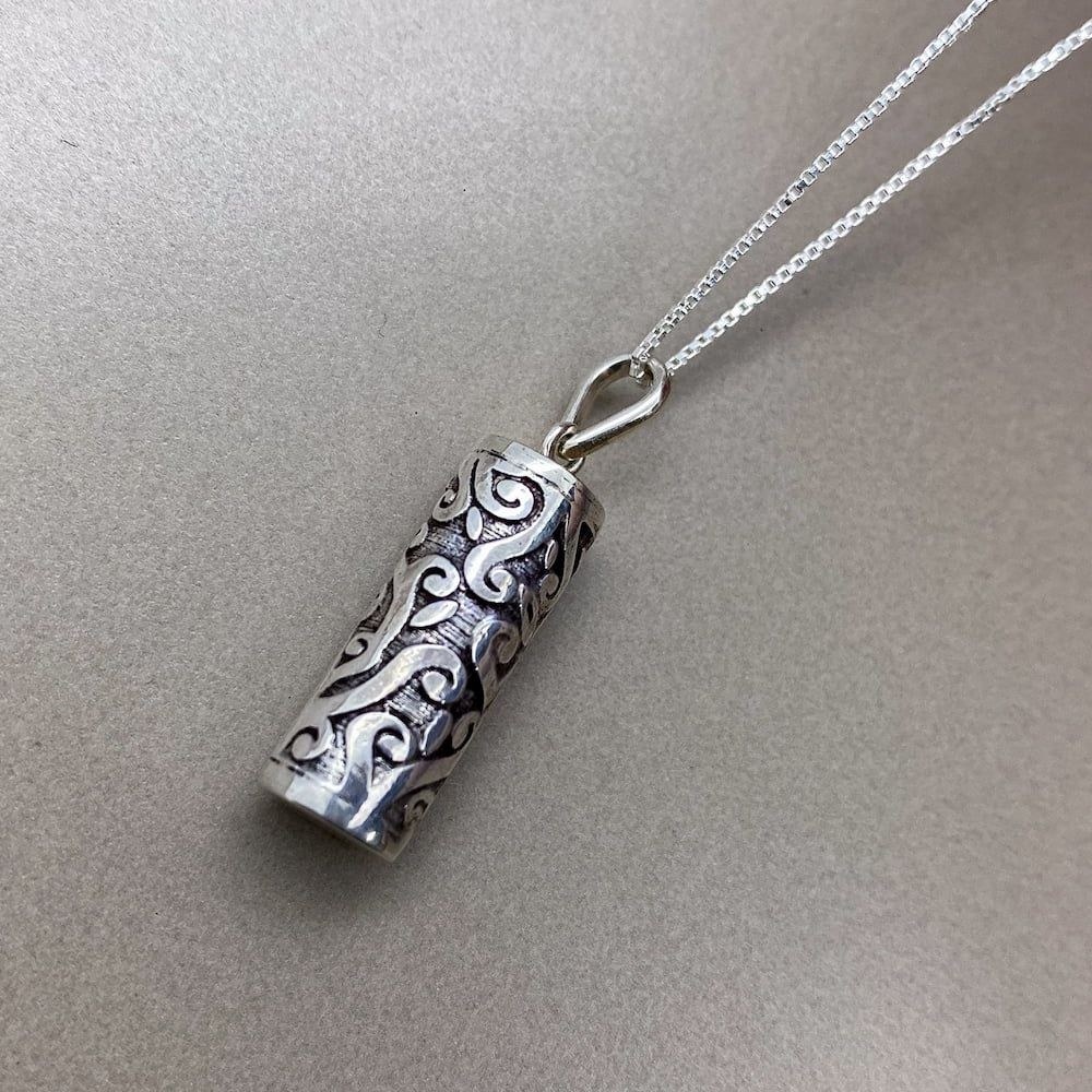 Pingente de prata em uma superfície lisa