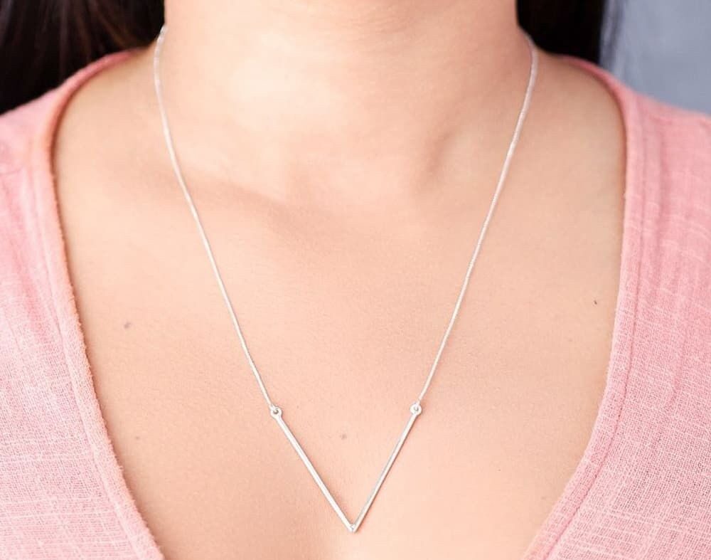 Moça jovem usando um colar V Grande