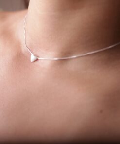 Modelo feminina de camisa verde usando um Choker Coração