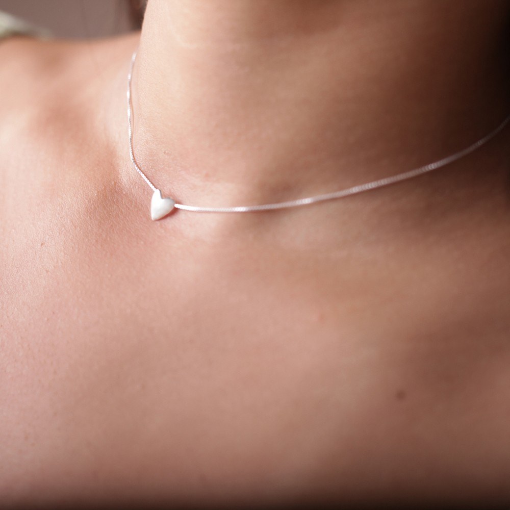 Modelo feminina de camisa verde usando um Choker Coração