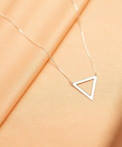 Foto do colar “Triangulo Vazado”, acima de uma base de tecido