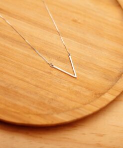 Foto do Colar V pequeno acima de uma base de madeira rústica