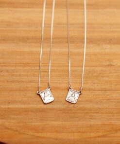 Foto do Escapulário santo mini acima de uma base de madeira rústica