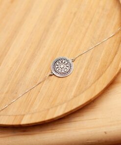 Foto da Pulseira Mandala acima de uma base de madeira rústica