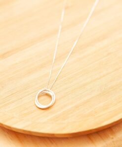 Colar de prata Nó de Marinheiro sobre uma superfície de madeira