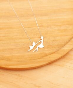 Foto do colar mãe e filha em prata 925 sobre um prato de madeira