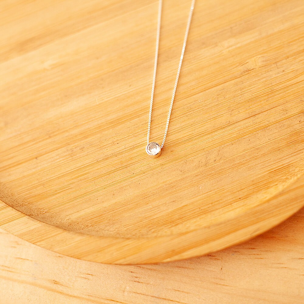 Colar de Prata 925 ponto de luz em um prato de madeira