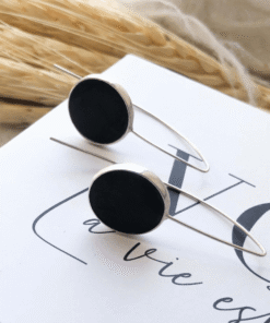 Brinco anzol agata negra em prata 925 em cima de um livro