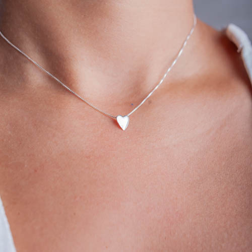 Modelo feminina de camisa branca usando um Choker Coração