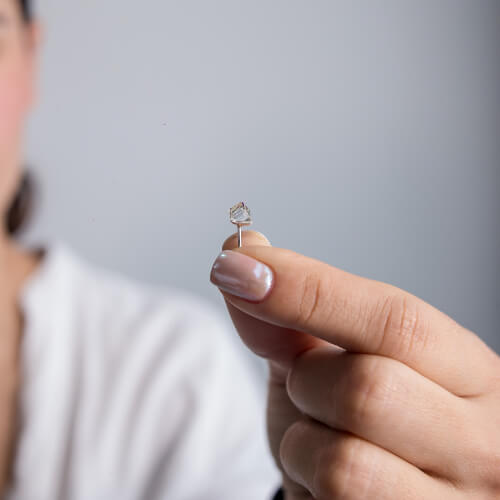 Modelo Feminina segunrando Brinco Cubo furta cor de prata 925